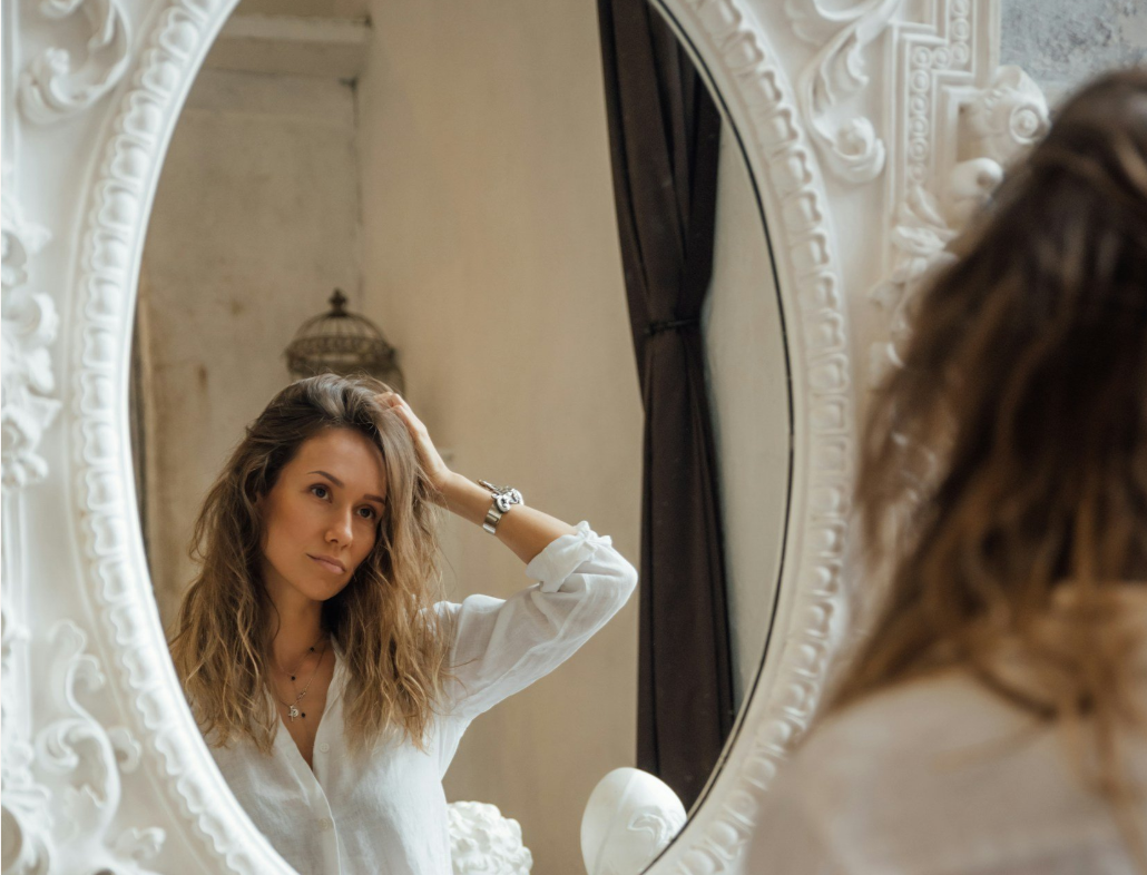 Frau vor Spiegel mit Haarproblemen